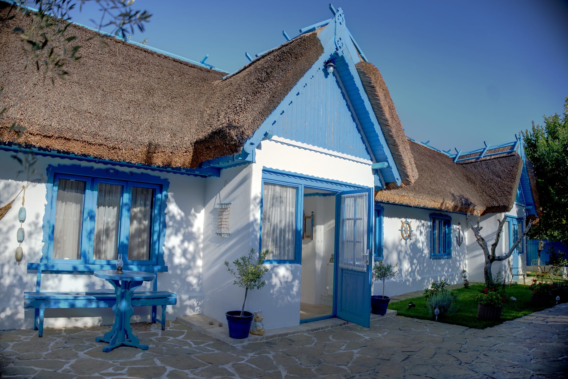 Casa Ilinca Jurilovca — casă lipovenească albă cu acoperiș de stuf și tâmplărie albastră, în lumina serii